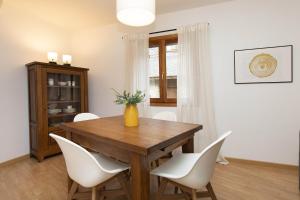 a dining room with a wooden table and white chairs at Rincón del Pueyo by BeValle in El Pueyo de Jaca +12 photos