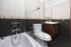 a bathroom with a toilet and a tub and a sink at Pirenaica by BeValle in Escarrilla