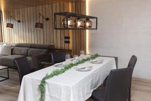 a dining room table with a white table cloth and chairs at Casa BellaVista by BeValle in Panticosa
