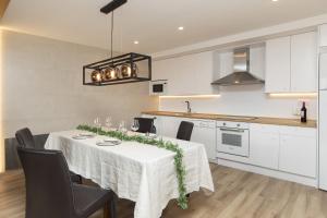 a kitchen with a table with a white table cloth at Casa BellaVista by BeValle in Panticosa +28 photos