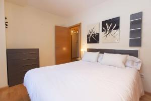 a bedroom with a large white bed and a dresser at Altos de Argualas by BeValle in Panticosa