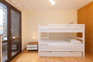 a white bunk bed in a room with a window at Altos de Argualas by BeValle in Panticosa