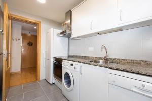 a kitchen with a sink and a washing machine at Casa de La Laguna by BeValle in Panticosa