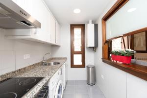 a kitchen with white cabinets and a sink and a window at Casa de La Laguna by BeValle in Panticosa