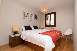 a bedroom with a bed with a red blanket on it at Casa de La Laguna by BeValle in Panticosa