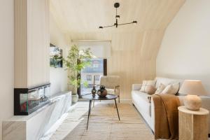 a living room with a white couch and a fireplace at CiMa Panticosa by BeValle in Panticosa