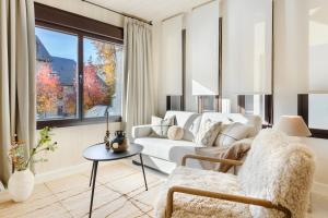 a living room with a white couch and a table at CiMa Panticosa by BeValle in Panticosa
