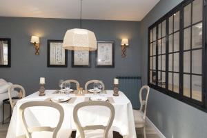 a dining room with a white table and chairs at El Ciervo de Santa María by BeValle in Panticosa