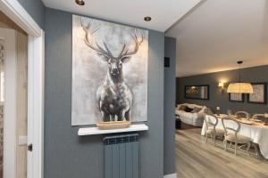 a painting of a deer on a wall in a living room at El Ciervo de Santa María by BeValle in Panticosa +28 photos