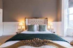 a bedroom with a large bed with two lamps at The Tontine Hotel in Greenock