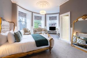a bedroom with a large bed with a large mirror at The Tontine Hotel in Greenock