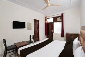 a bedroom with a bed and a chair and a television at Super Hotel O Sector 45 A Chandigarh Formerly Sangam in Chandīgarh +23 photos