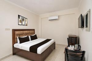 a bedroom with a bed and a television in it at Super Hotel O Sector 45 A Chandigarh Formerly Sangam in Chandīgarh