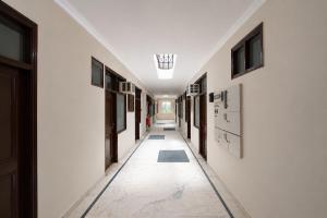 a hallway with white walls and a hallway with windows at Super Hotel O Sector 45 A Chandigarh Formerly Sangam in Chandīgarh