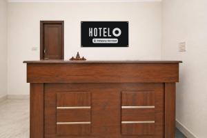 a wooden counter in a room with a sign on the wall at Super Hotel O Sector 45 A Chandigarh Formerly Sangam in Chandīgarh