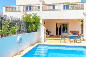 a villa with a swimming pool and a house at Villa Lagoa in Cala Dor in Cacla D'or