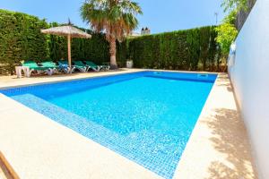 a swimming pool with blue water in a yard at Villa Lagoa in Cala Dor in Cacla D'or