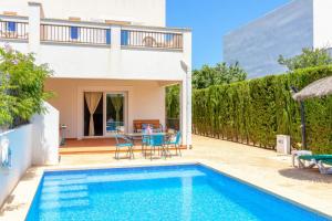 a villa with a swimming pool and a house at Villa Lagoa in Cala Dor in Cacla D'or