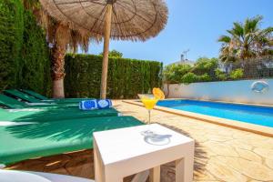 a table with a drink on it next to a pool at Villa Lagoa in Cala Dor in Cacla D'or +36 photos