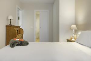 a bedroom with a large white bed and a dresser at El Rincón del Verde by BeValle in Panticosa