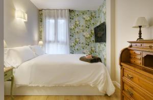 a bedroom with a white bed and a window at El Rincón del Verde by BeValle in Panticosa