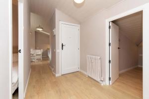 an empty room with a white door and wooden floors at Ático del Prado by BeValle in Sallent de Gállego +14 photos