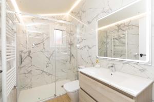 a white bathroom with a sink and a mirror at Ático del Prado by BeValle in Sallent de Gállego