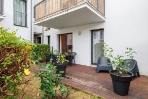 a patio with plants and chairs on a wooden deck at Laïta - Séjour à Quimperlé in Quimperlé