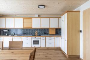 a kitchen with white cabinets and a wooden floor at Egg'spresso Gipfelglück in Egg