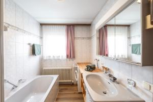 a bathroom with a tub and a sink and a mirror at Egg'spresso Gipfelglück in Egg +24 photos