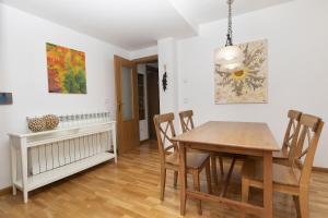 a dining room with a wooden table and chairs at Casa Eguzkilore by BeValle in Escarrilla