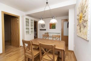 a dining room and kitchen with a wooden table and chairs at Casa Eguzkilore by BeValle in Escarrilla