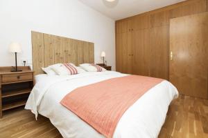 a bedroom with a large white bed and wooden cabinets at Casa Eguzkilore by BeValle in Escarrilla +18 photos