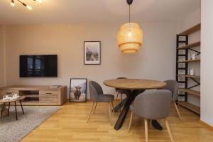 a dining room with a table and chairs and a tv at Casa Lluna by BeValle in El Pueyo de Jaca