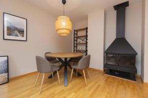 a dining room with a table and chairs and a stove at Casa Lluna by BeValle in El Pueyo de Jaca