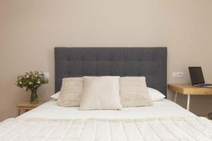 a bedroom with a white bed with a gray headboard at Casa Lluna by BeValle in El Pueyo de Jaca +16 photos