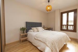 a bedroom with a bed and a window at Casa Lluna by BeValle in El Pueyo de Jaca
