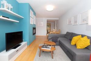 a living room with a gray couch and a blue wall at Narnia by BeValle in Panticosa