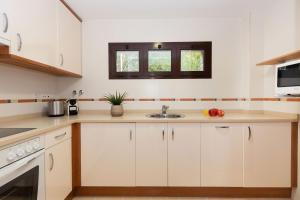 a kitchen with white cabinets and a sink at Narnia by BeValle in Panticosa +20 photos