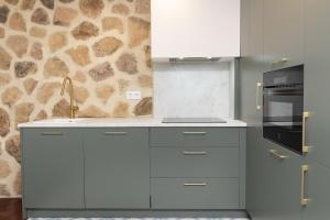 a kitchen with white cabinets and a sink at Partacua by BeValle in Tramacastilla de Tena