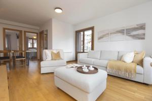 a living room with two white couches and a table at Sueños de Telera by BeValle in El Pueyo de Jaca