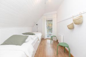 a white bedroom with two beds and a green stool at Panorámica del Valle II by BeValle in Panticosa