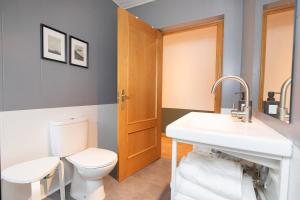 a bathroom with a toilet and a sink at Panorámica del Valle II by BeValle in Panticosa