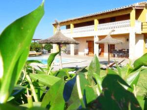 a house with a pool and two umbrellas at Villa Son Fanals in Alcudia