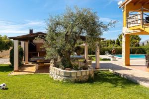 a tree in a yard next to a house at Villa Son Fanals in Alcudia
