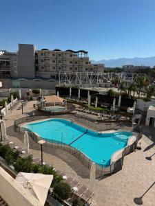 a large swimming pool with chairs and a building at sea&sky luxury suite מילה דירות אירוח in Eilat