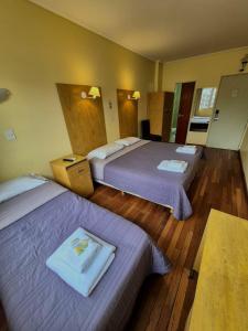 a hotel room with two beds and a table at Hotel Juramento in Buenos Aires
