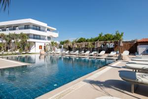 a pool at a resort with lounge chairs at Aquarius Beach Hotel in Faliraki