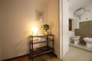 a bathroom with a toilet and a lamp on a shelf at Stanza del Cerro in Aranova