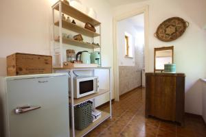 a kitchen with a refrigerator and a microwave at Stanza dell'Ulivo in Aranova +24 photos